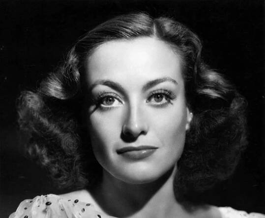 Grayscale Portrait Publicity photo of Joan Crawford in a white floral dres