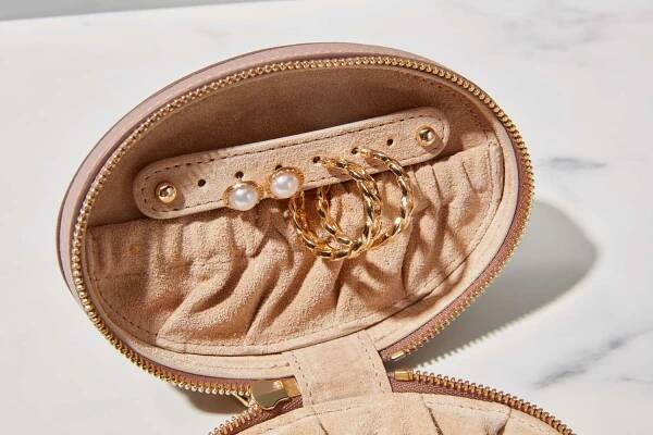 An open Cuyana Travel Jewelry Case on a marble background