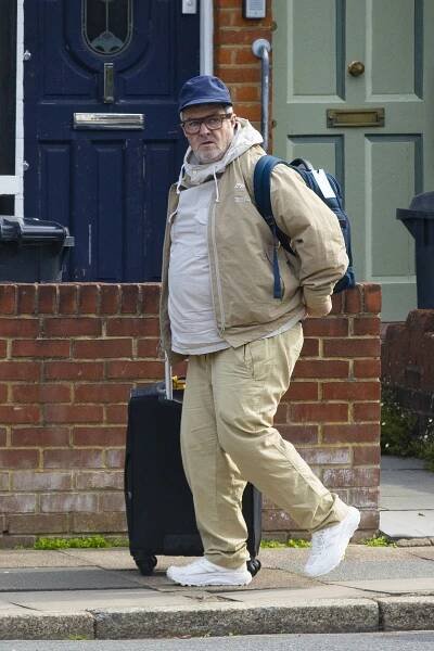 Paul Gallagher, brother of Liam and Noel Gallagher, walking with a suitcase.