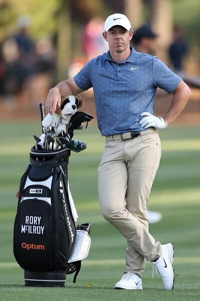 Rory McIlroy leaning on his golf bag.
