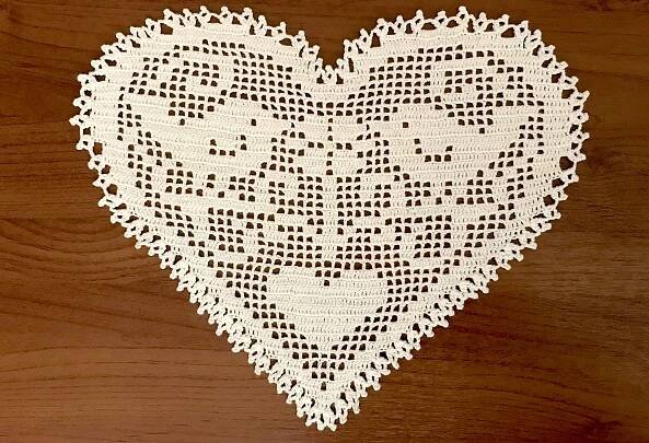 a heart shaped doily on a wooden surface