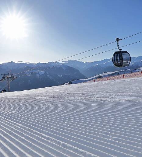 Sonniger Wintertag mit Gondel und frisch präparierter Piste in Großarl | © Grossarler Bergbahnen GmbH & Co KG