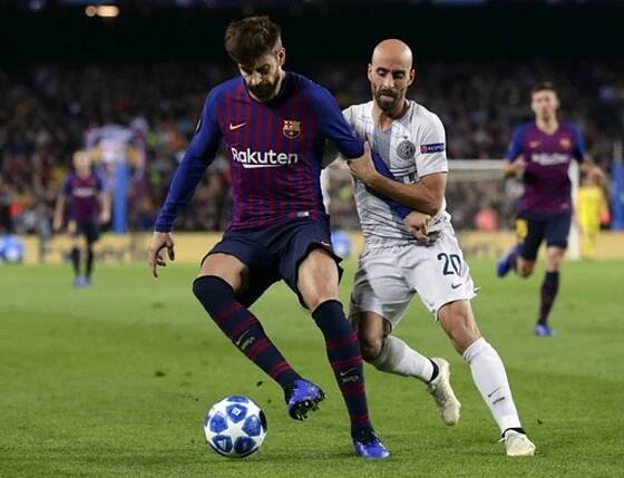 FC Barcelona - Inter Milán.  Vlevo Gerard Pique z Barcelony, vpravo Borja Valero z Interu.