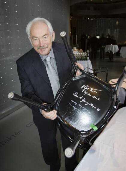 Peter Grünberg autographs a chair