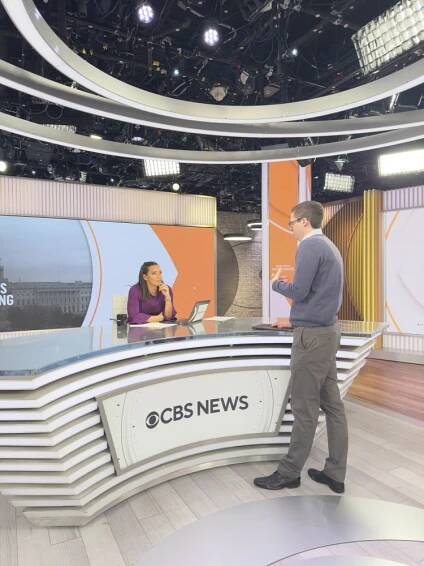 A producer speaks with a CBS anchor