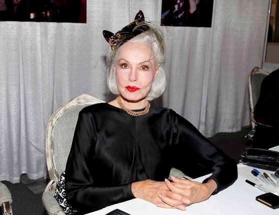 Julie Newmar seated at a table