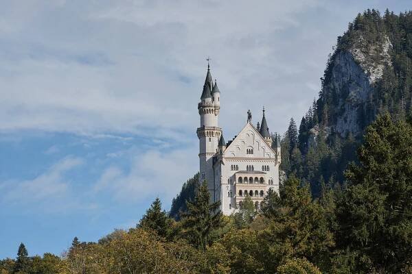 Das Schloss Neuschwanstein mit Turmspitze umgeben von Bäumen