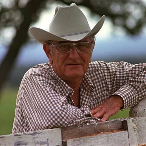 Portrait of Lyndon B. Johnson, with his arms resting on a fence, at the LBJ ranch.