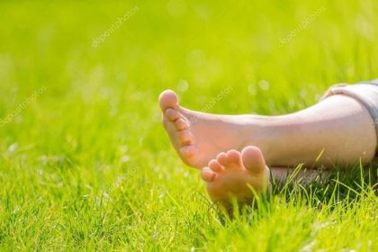 Stáhnout - Ženské bosé nohy na zelené trávě — Stock obrázek