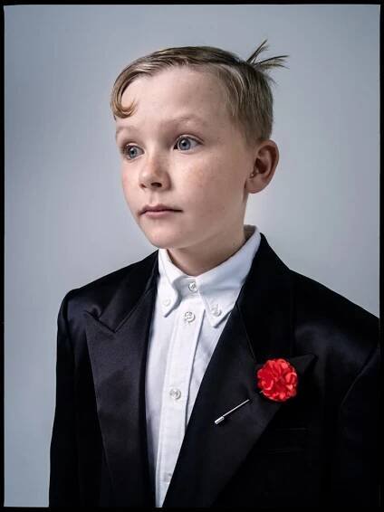 Jude Hill wears a Saint Laurent by  Anthony Vaccarello coat; Raf Simons shorts; Thom Browne shirt; F...