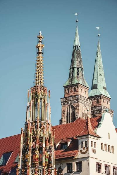 Die Spitze der Pyramide des Schönen Brunnens am Nürnberger Hauptmarkt. Im Hintergrund sind die Türme der Kirche St. Sebaldus zu sehen