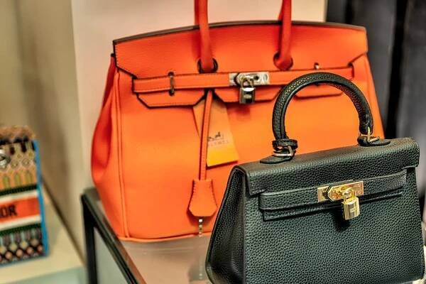 Two high-end handbags on a stand.
