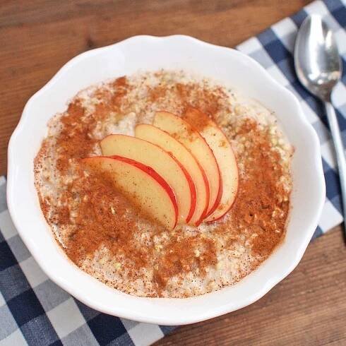 a bowl of oatmeal with apples on top