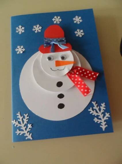 a paper snowman with a red hat and scarf