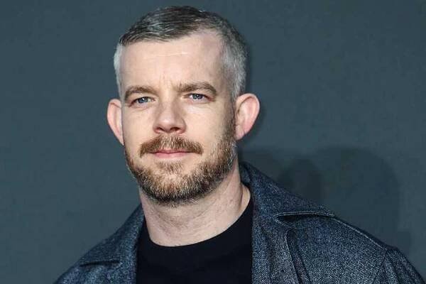 Russell Tovey with a slight smile on the red carpet for an event