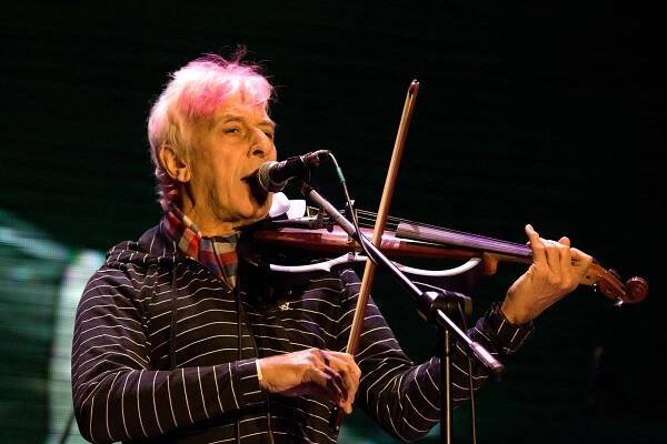 Zpívající muž za mikrofonem hrající na violu.