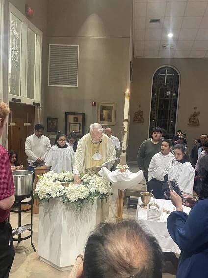 Father blessing the waters of the font