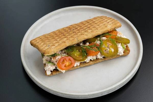 a white plate topped with a sandwich on top of a table