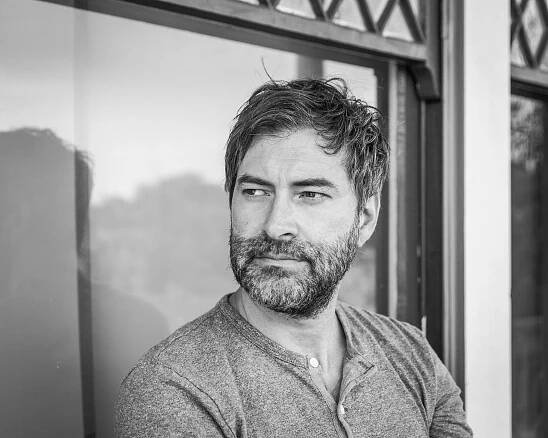 Black and white photograph of Mark Duplass looking to the side