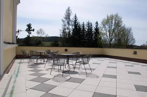 a group of tables and chairs on a patio at Penzion Zámek Rozsochatec in Rozsochatec