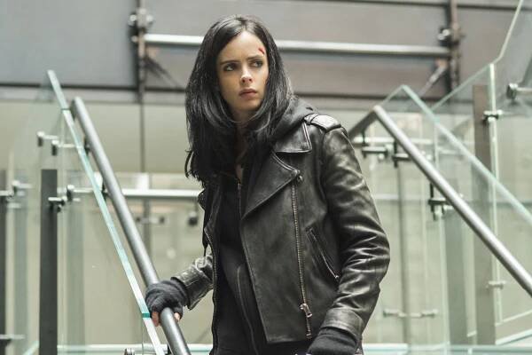 a woman in a leather jacket is walking down the stairs