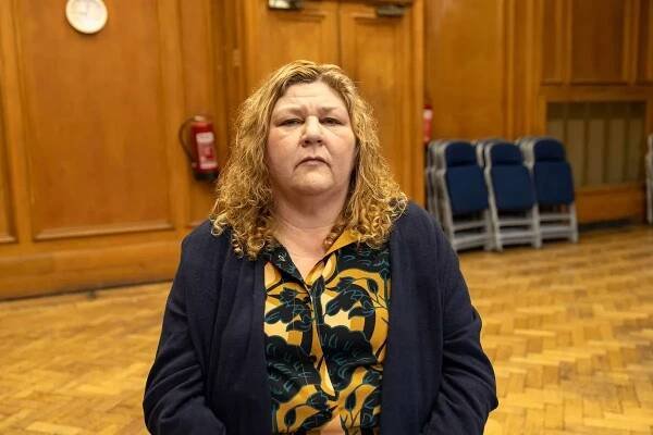 Cheryl Fergison as Stella, sat with a stern expression in an empty room in the comedy series Mandy
