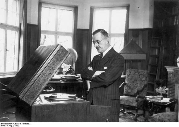 Thomas Mann in seiner Wohnung vor einem Grammophon