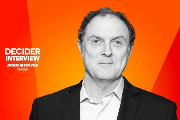 Boris McGiver in black and white on a bright orange background