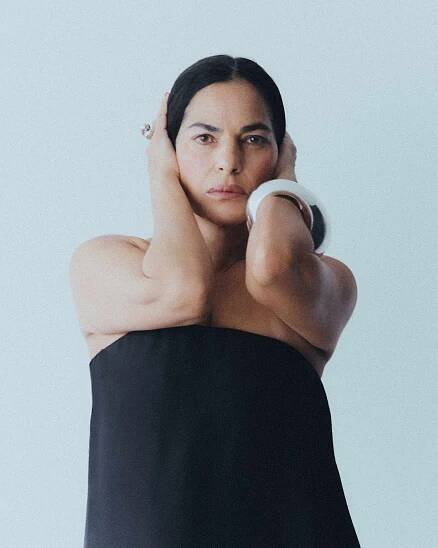 Sarita Choudhury facing the camera, hands by her head