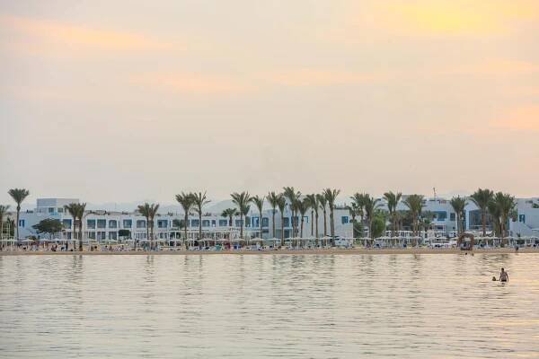 a view of a beach with palm trees and buildings at Casa Blue Resort in Marsa Alam City