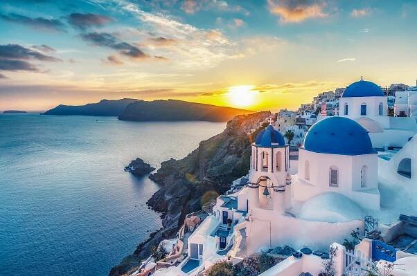 Fototapeta Krásný výhled na kostely ve vesnici Oia, ostrov Santorini v Řecku při západu slunce, s dramatickou oblohu.