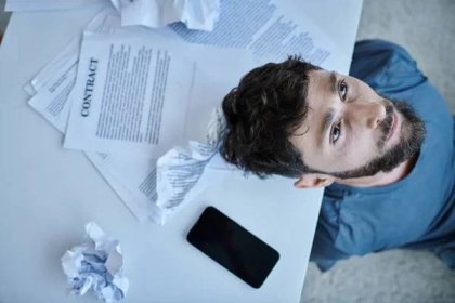 Shora pohled na depresivní muž s smartphonem s papíry a kontrakt v jeho blízkosti při duševním zhroucení — Stock obrázek