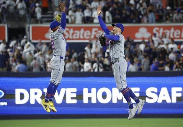 New York Mets shortstop Francisco Lindor and left fielder Brandon Nimmo celebrating after winning a game against the New York Yankees at Yankee Stadium.