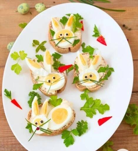 small sandwiches with bunny faces on them sitting on a white plate