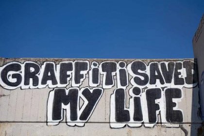 Image of graffiti and street art in Holesovice with 'Graffiti saved my life' painted on wall 