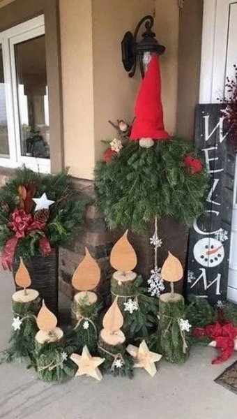 christmas wreaths and decorations are on display outside the front door of a house with an elf's hat on top