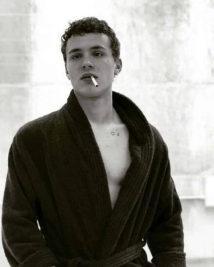 Aron Piper Poses For a Photo While Striking a Pensive Pose
