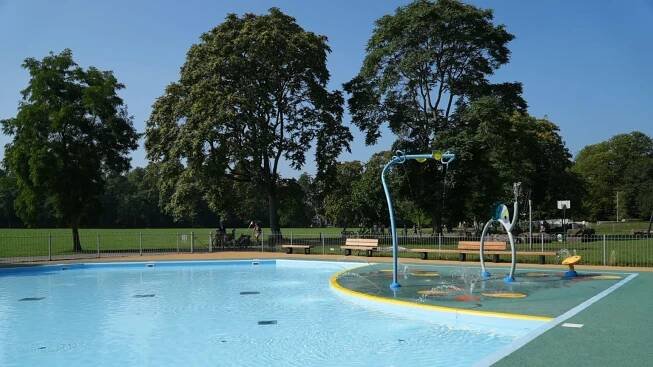 A splash park, with a large shallow area of water with a number of water play equipment