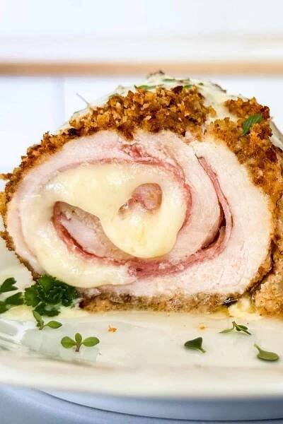 The inside of a chicken cordon bleu roll up shows the melty cheese and ham 'pinwheel.'