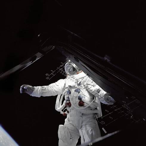 Astronaut Russell Schweickart, lunar module pilot, stands on the module's deck during his spacewalk on the fourth day of the Apollo 9 mission. This photograph was taken from inside the lunar module Spider by mission commander James McDivitt. Apollo 9 was the first manned flight of the command/service module along with the lunar module. The mission's three-person crew, which also included command module pilot Dave Scott, tested several aspects critical to landing on the moon including the lunar module's engines, backpack life support systems, navigation systems and docking maneuvers. The mission was the second manned launch of a Saturn V rocket and was the third manned mission of the Apollo Program. After launching on March 3, 1969, the crew spent 10 days in low Earth orbit. 