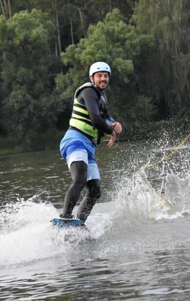 A man on a wakeboard in Jedovnice throwing a rope