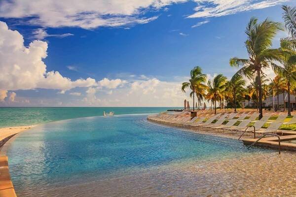 kulečníková lehátka u tyrkysové vody na tropické pláži a bazén v karibském moři, freeport, bahamy - freeport grand bahama - stock snímky, obrázky a fotky