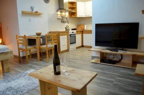 a living room with a bottle of wine on a table at Apartmány Nová duha Vavřinec in Vavřinec