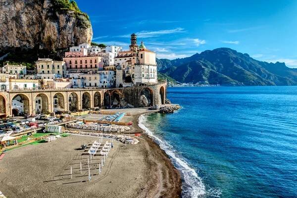 Atrani, Amalfi coast, Italy, a town set against a cliffside overlooking a beach and the sea.