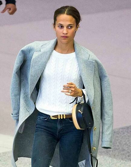 EXCLUSIVE: Newlywed Alicia Vikander shows off her wedding ring as she arrives in Miami without husband Michael Fassbender.