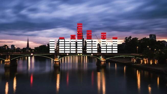 Skyline von Frankfurt am Main bei Nacht, davor rot-weiße Balken, die eine Tonspur nachstellen.