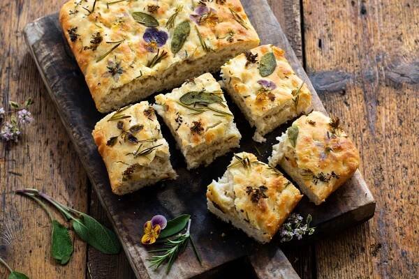 Obraz na plátně Freshly baked focaccia with herbs and flowers