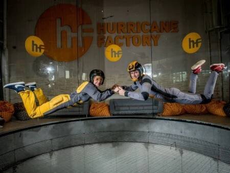 dvě osoby létají ve větrném tunelu (Hurricane Factory) v Praze
