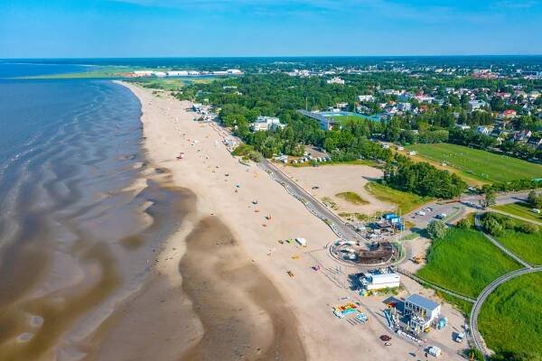 an aerial view of a sandy beach with a city in the background