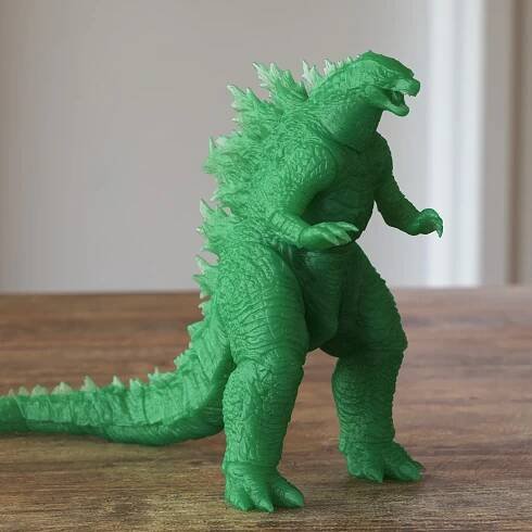 Small action figure of a Godzilla toy made of a green plastic on the table product rendering tutorial